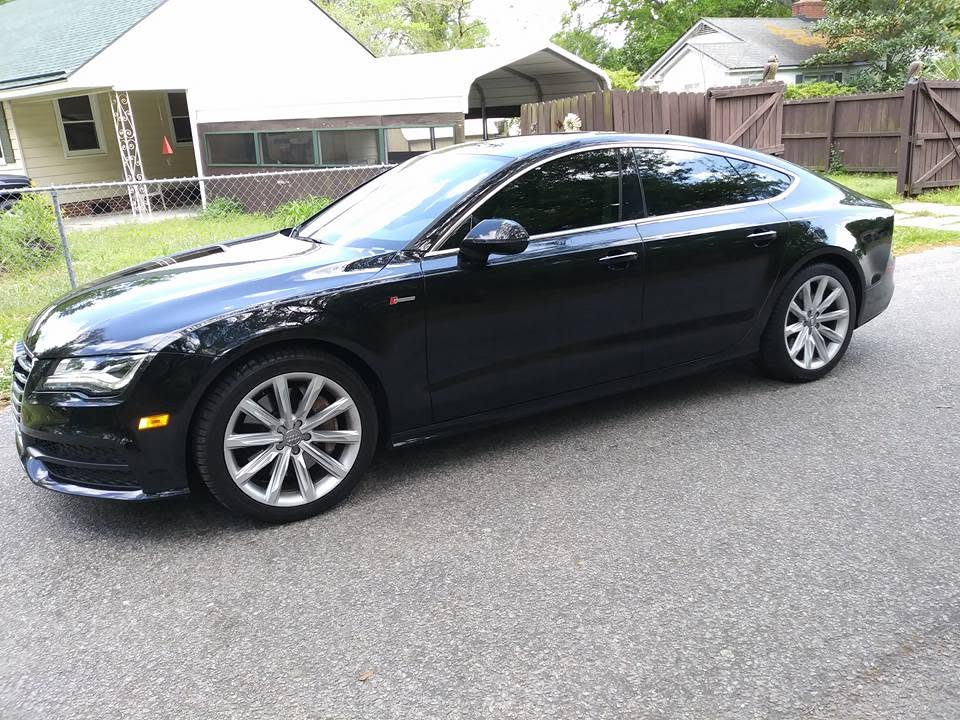 Black Audi sedan with dark tinted windows parked outdoors