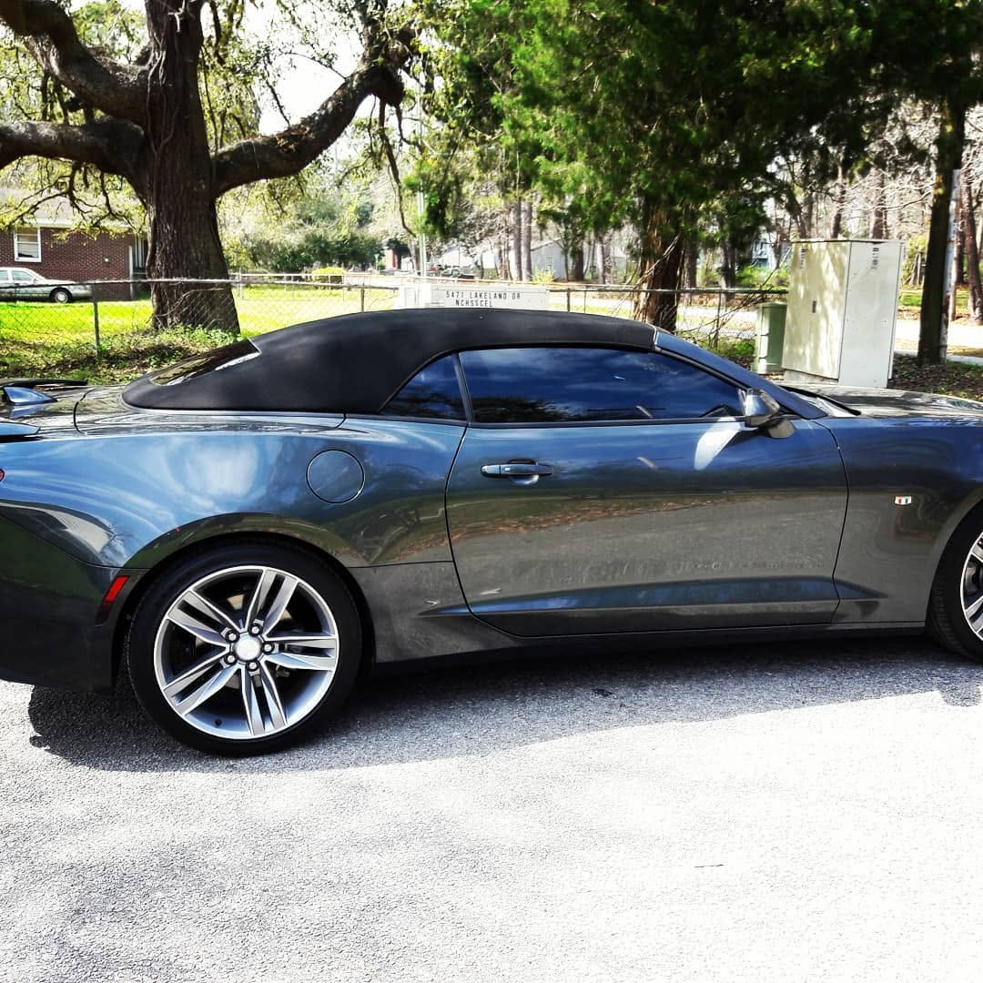Blue convertible with a dark soft top and tinted side windows