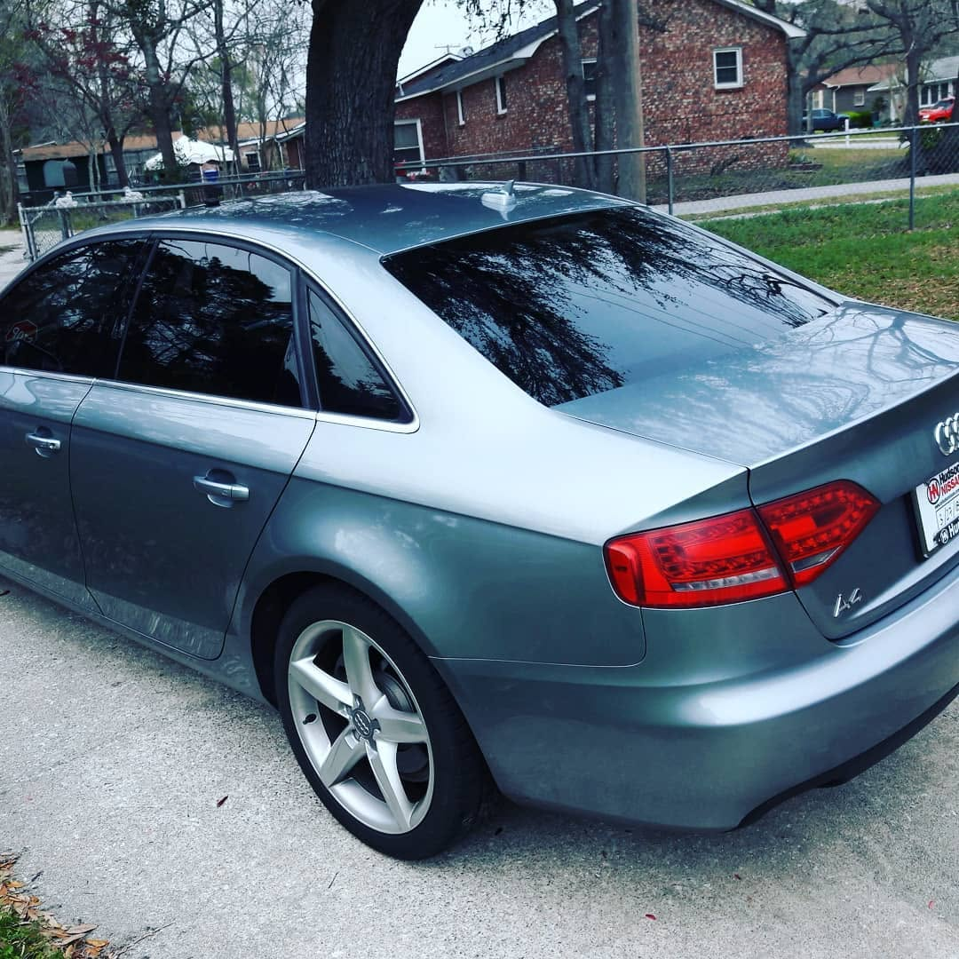 Silver Audi sedan with dark tinted rear and side windows