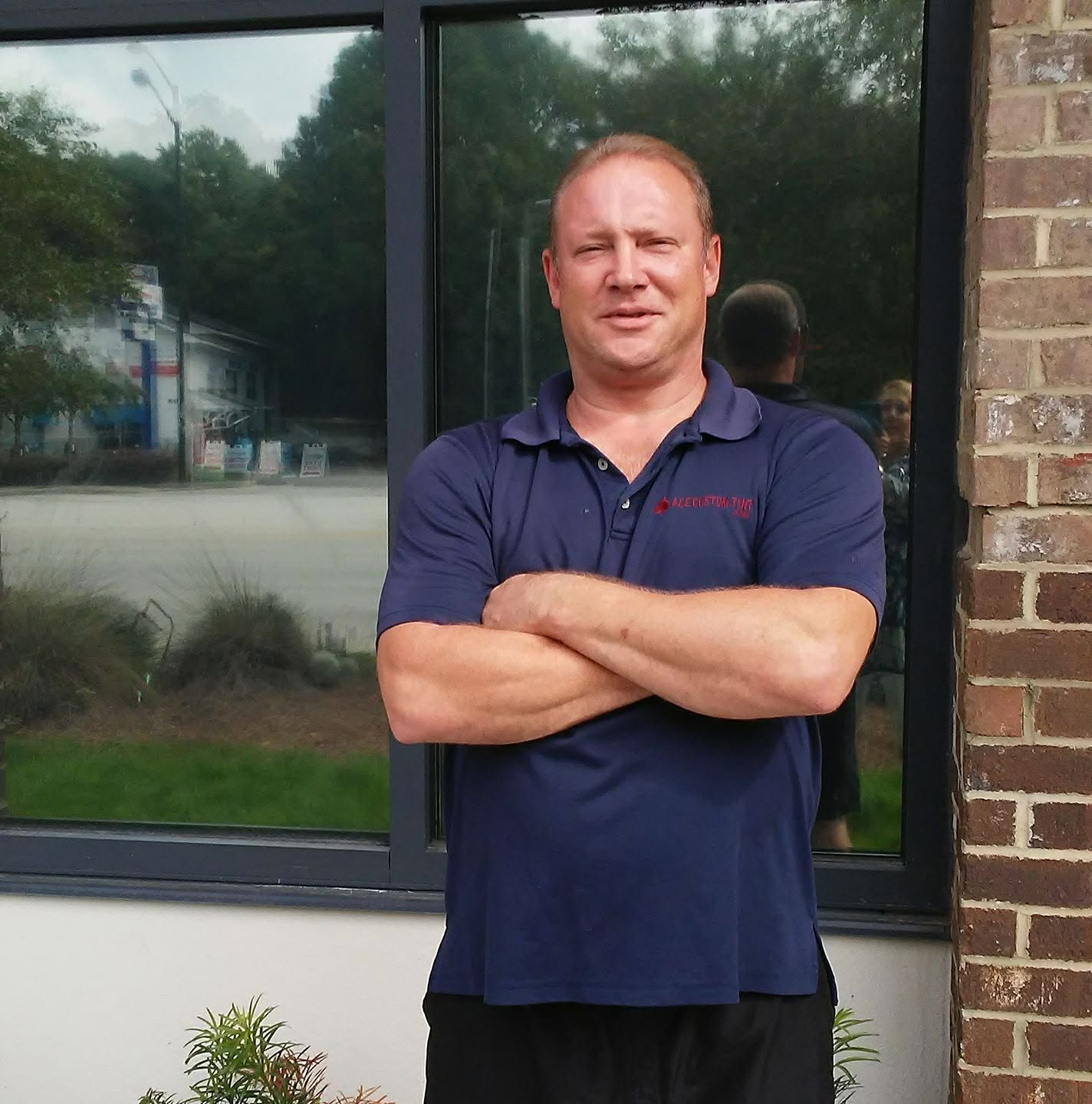 ACE Custom Tint owner standing in front of a completed commercial window film installation
